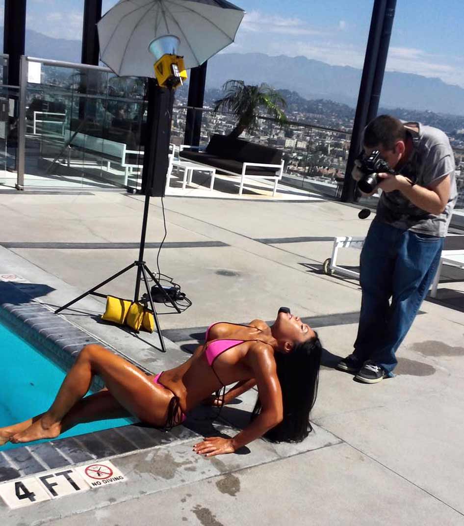 Antonio Carrasco does fitness photo shoot with model on rooftop deck of skyscraper building in Los Angeles