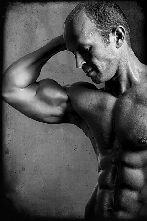 Bodybuilder flexes bicep for fitness photography shoot in Los Angeles