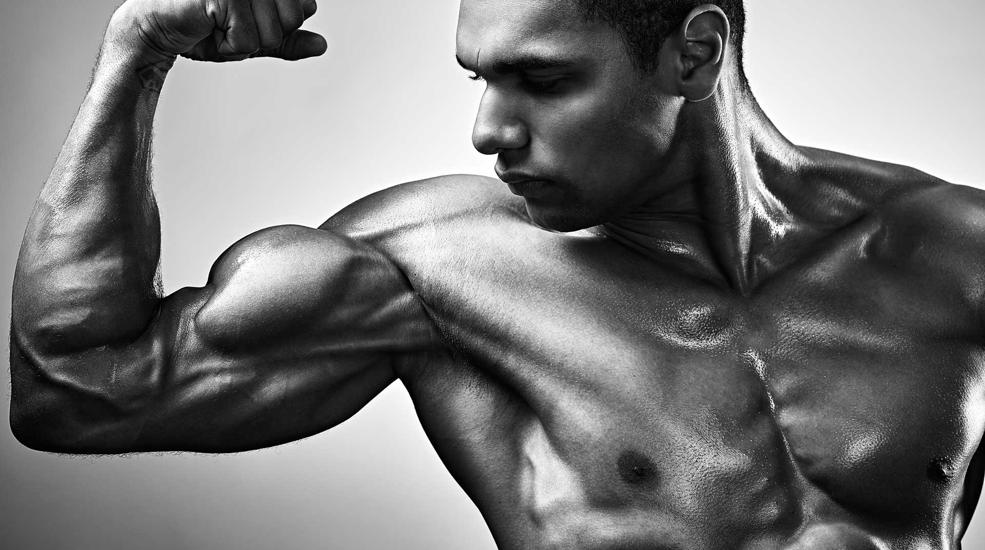 Bodybuilder flexes his biceps for studio photo shoot