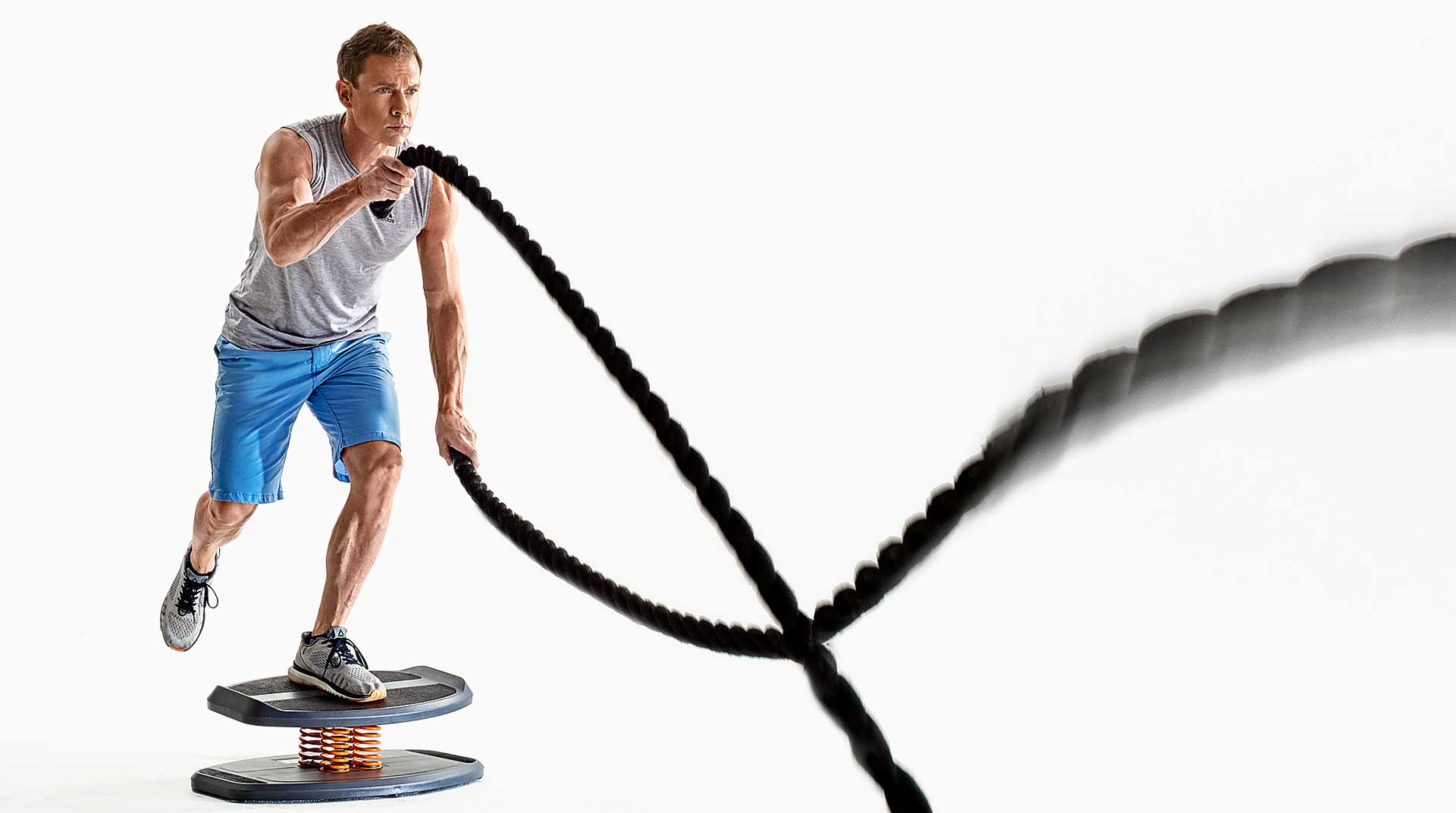 Photo shoot of personal trainer using heavy ropes to build arm strength