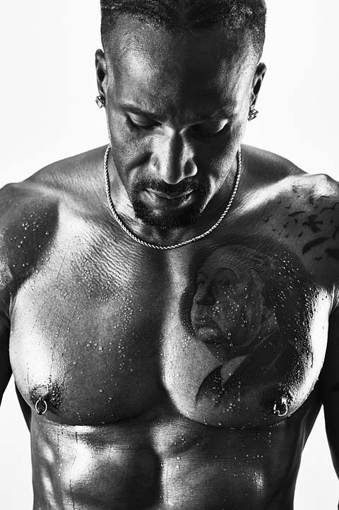 Black and white portrait of muscular male with artistic tattoos